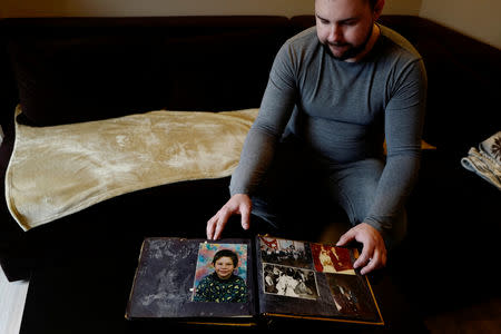 Mariusz Milewski, 28, shows his photo album with pictures from when he was in primary school at his house in Wardegowo village, Poland, February 17, 2019. Picture taken February 17, 2019. REUTERS/Kacper Pempel