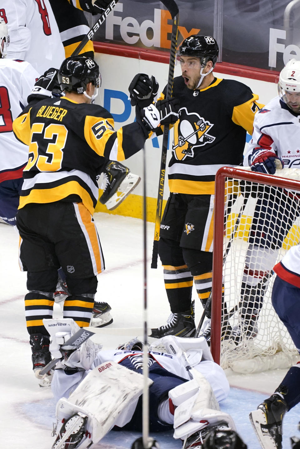 Pittsburgh Penguins' Colton Sceviour (7) celebrates his goal with Teddy Blueger (53) as Washington Capitals goaltender Craig Anderson lies in the goal crease during the first period of an NHL hockey game in Pittsburgh, Tuesday, Jan. 19, 2021. (AP Photo/Gene J. Puskar)