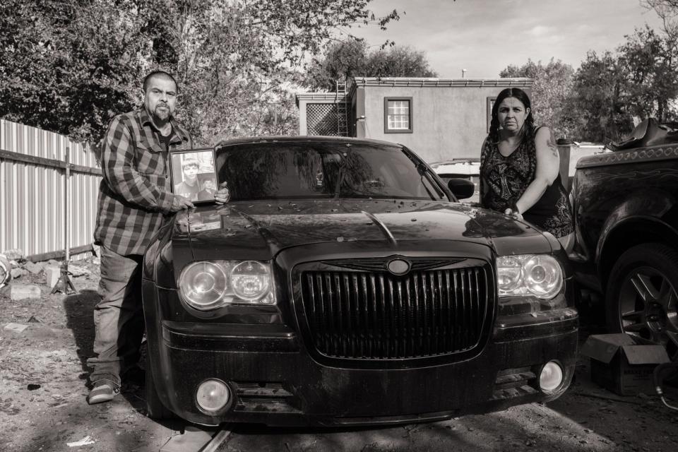 Vincent Chavez Sr. and Kimberly Chavez stand on either side of their son’s prized car, left behind in the yard of the family home.