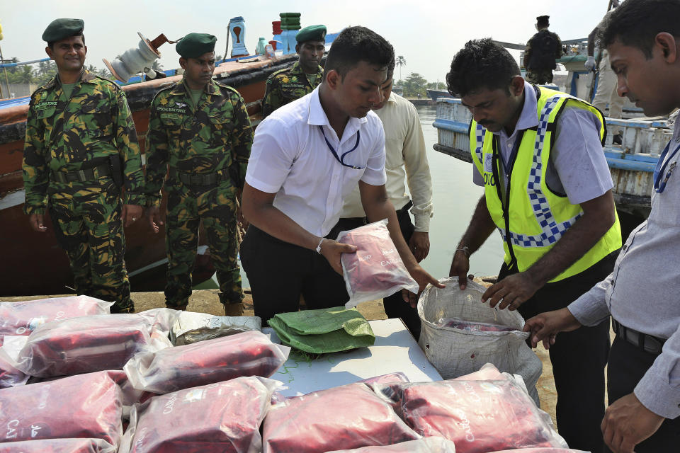 Sri Lankan police officers belonging to the narcotics unit stack up a seized haul of narcotics at a fishery harbor in Colombo, Sri Lanka, on May 3, 2020. For years, authorities in Sri Lanka have tried to rid the Indian Ocean island nation of illegal drugs. But a drug ring allegedly including more than a dozen officers from a key national narcotics unit has exposed how much of a challenge that goal brings. (AP Photo)