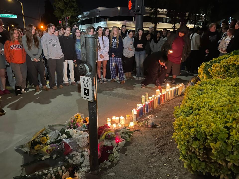 Mourners light candles at Westlake High School Tuesday night after a driver struck four students, killing one, earlier in the day.