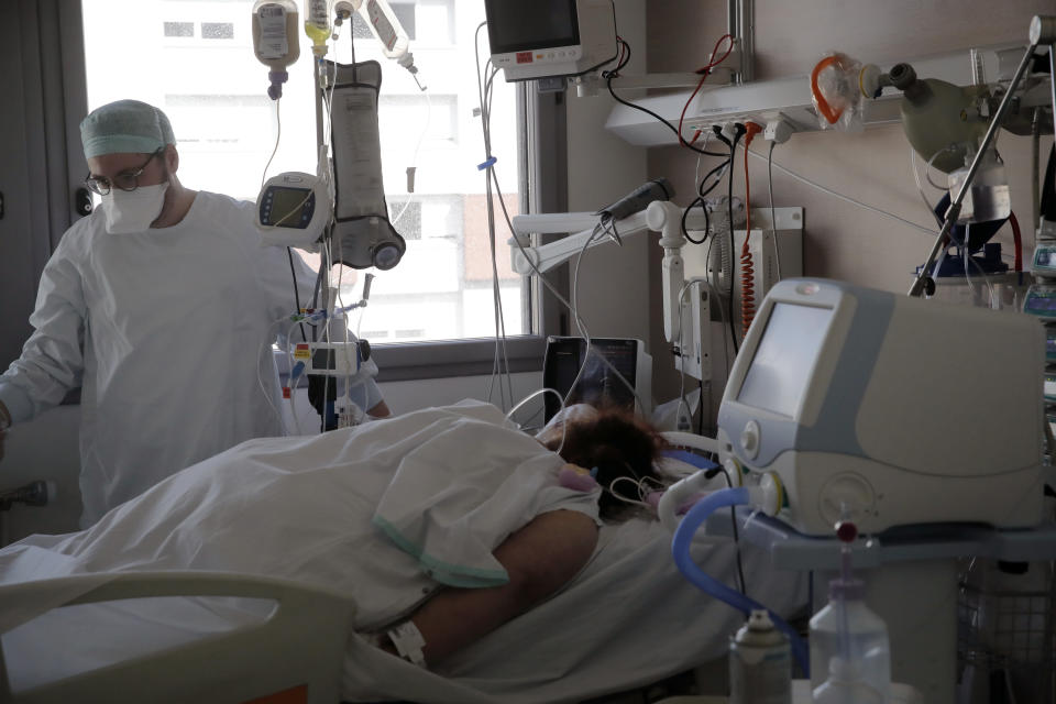 A nurse tends to a patient affected by the COVID-19 virus in the ICU unit at the Charles Nicolle public hospital, Thursday, April 15, 2021 in Rouen, France. A renewed crush of COVID-19 cases is again forcing intensive care units across France to grapple with the macabre mathematics of how to make space for thousands of critically ill patients (AP Photo/Christophe Ena)