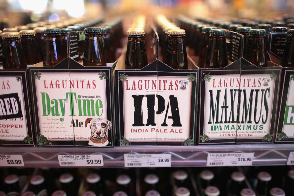 Six-packs of beer for sale in a refrigerator.