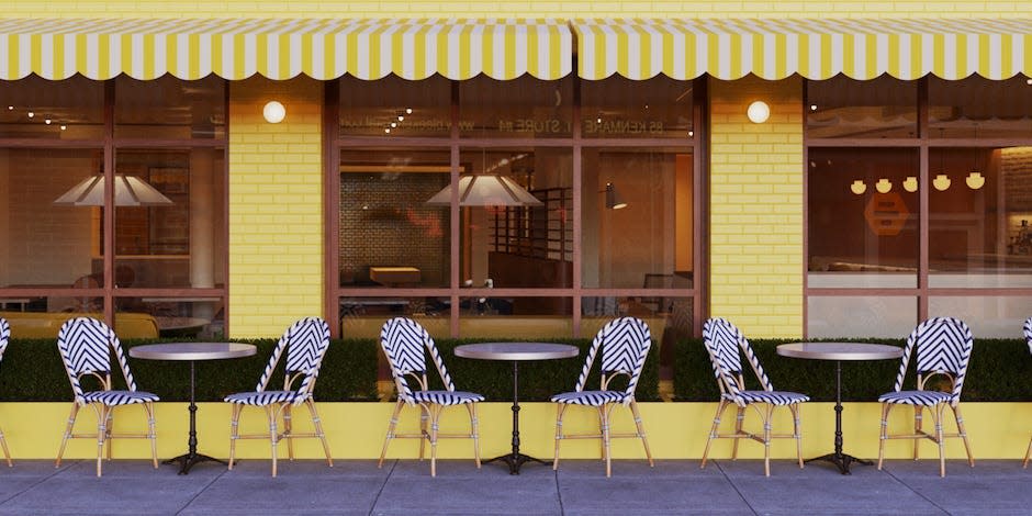 A rendering of the exterior of Bumble Brew with tables and chairs both outside and inside the yellow storefront