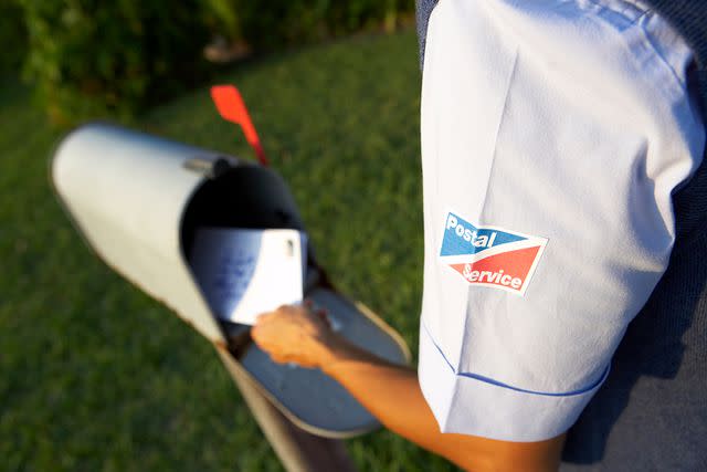 <p>Getty</p> Postal worker delivers mail.