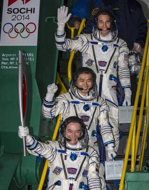 Japanese astronaut Koichi Wakata, center, Russian cosmonaut Mikhail Tyurin, bottom and U.S. astronaut Rick Mastracchio, crew members of the next mission to the International Space Station, pose with an Olympic torch prior the launch of Soyuz-FG rocket at the Russian leased Baikonur cosmodrome, Kazakhstan, Thursday, Nov. 7, 2013. The crew will deliver Olympic torch to space as part of the ongoing Olympic torch relay. The torch will be brought back along with the station's current crew. (AP Photo/Shamil Zhumatov, Pool)