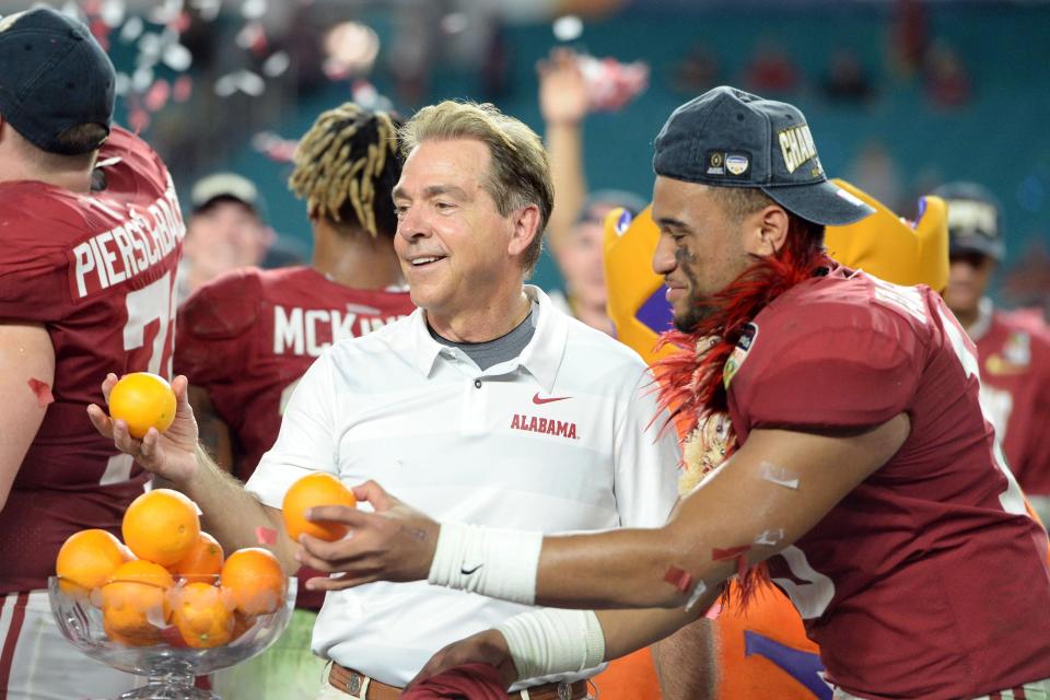 Alabama coach Nick Saban and quarterback Tua Tagovailoa throw oranges after defeating Oklahoma in the 2018 Orange Bowl at Hard Rock Stadium.