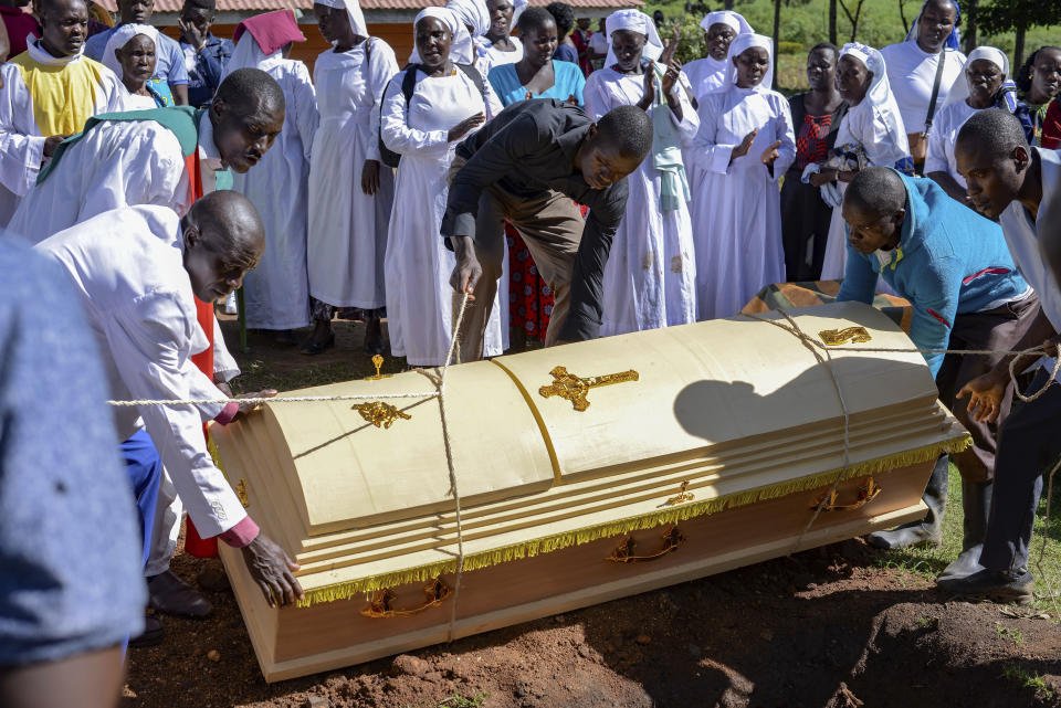 Friends and family lower the casket of Rose Bella Awuor, 31 years, after a funeral service at her home in Awendo, Migori County, Kenya Thursday, April. 11, 2024. Awuor fell ill in December and lost her five-month pregnancy before succumbing to malaria. It was the latest of five deaths in this family attributed to malaria. The disease is endemic to Kenya and is preventable and curable, but poverty makes it deadly for those who can't afford treatment. (AP Photo/Brian Ongoro)