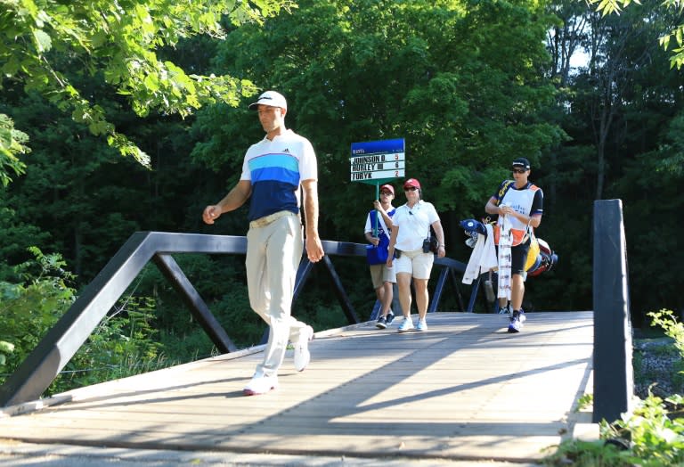 Dustin Johnson of the US walks over a bridge on his way to 12th tee during the second round of the RBC Canadian Open, at Glen Abbey Golf Club in Oakville, Ontario, on July 22, 2016