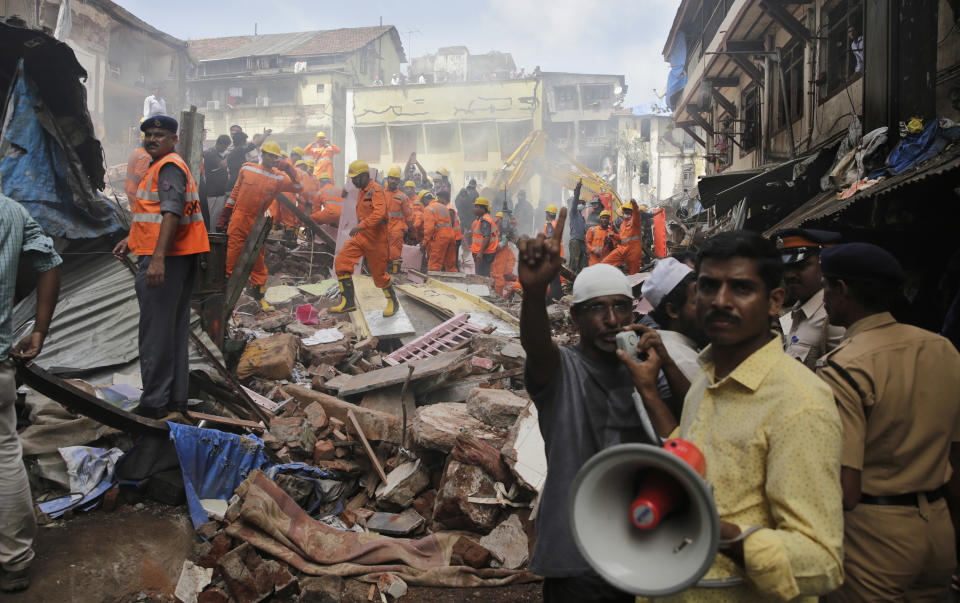 <p>A rescue worker makes an announcement on a loudspeaker at the site of a building collapse in Mumbai, India, Aug. 31, 2017. (Photo: Rafiq Maqbool/AP) </p>