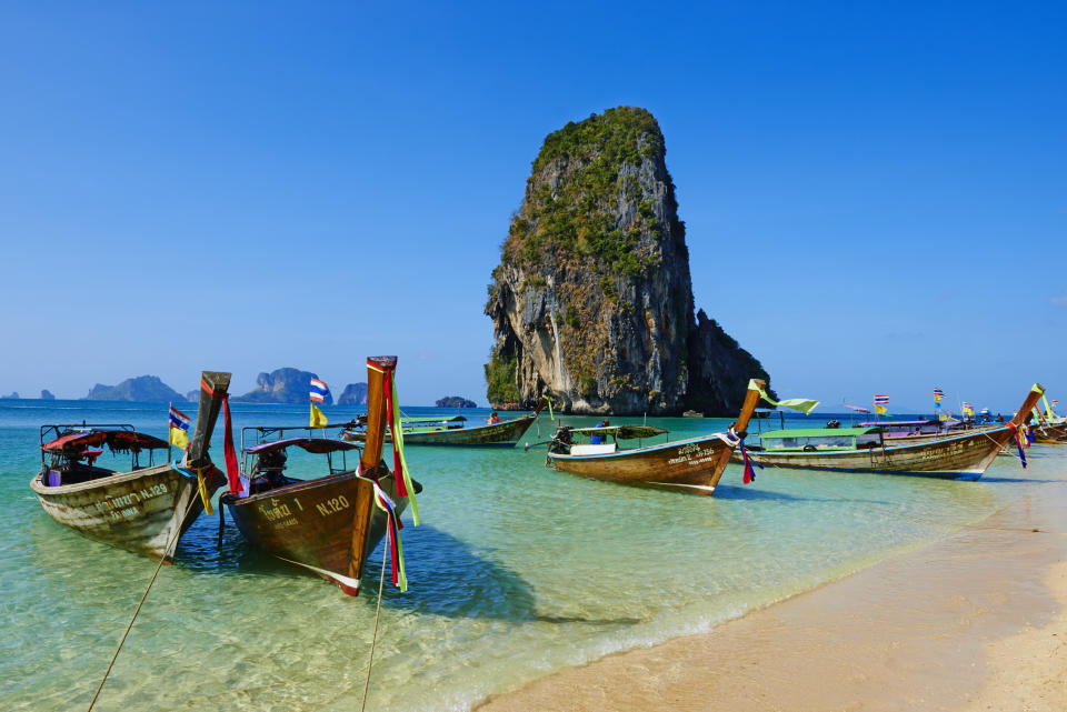 Turquoise blue water with ships lining the shore line in Thailand