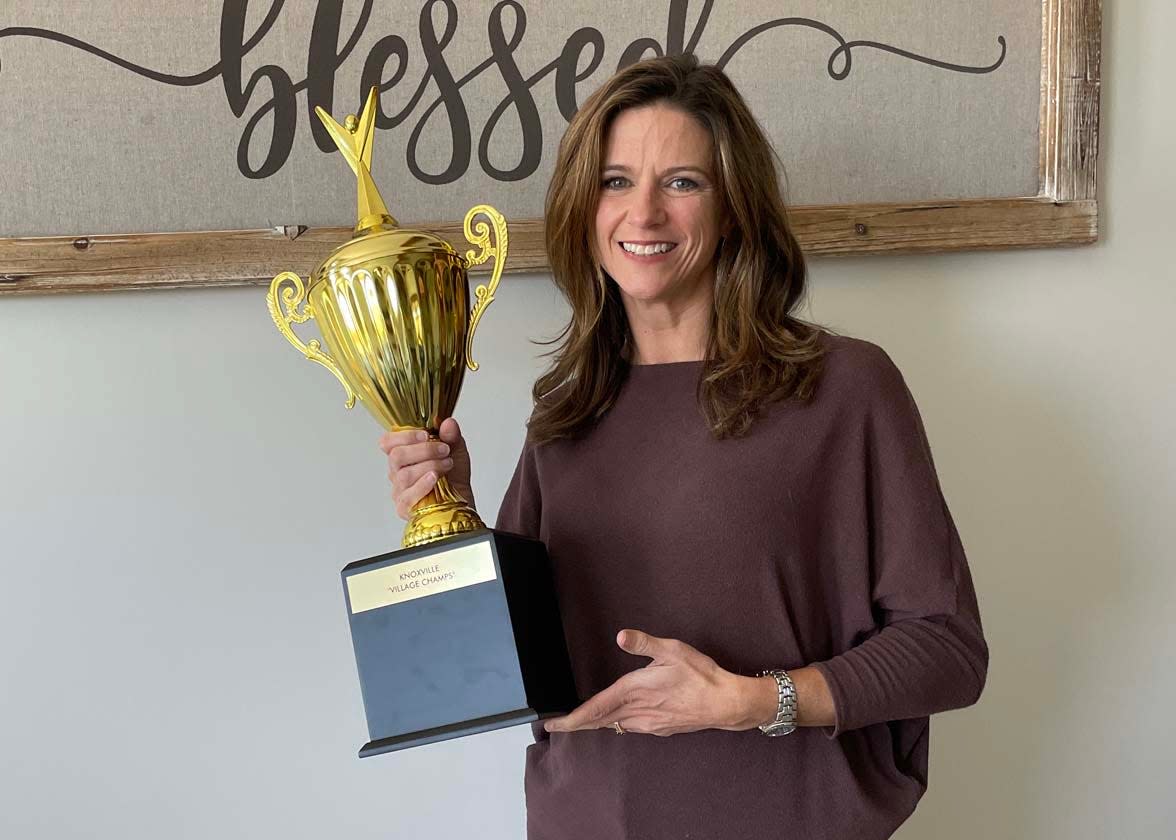 Kelly Orrico, executive director of the Widowed Parent Relief Project, shows off the winning trophy for the Family Friendzy games held April 30, 2023, at Knoxville Catholic High School.