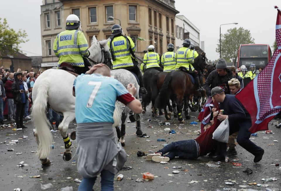 Britain Soccer Football - West Ham United v Manchester United - Barclays Premier League - Upton Park - 10/5/16 A West Ham fan lies on the ground as fans clash with police outside the stadium before the match Reuters / Eddie Keogh Livepic EDITORIAL USE ONLY. No use with unauthorized audio, video, data, fixture lists, club/league logos or "live" services. Online in-match use limited to 45 images, no video emulation. No use in betting, games or single club/league/player publications. Please contact your account representative for further details.