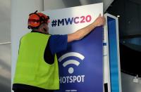 An employee places a banner with information of MWC20 in Barcelona