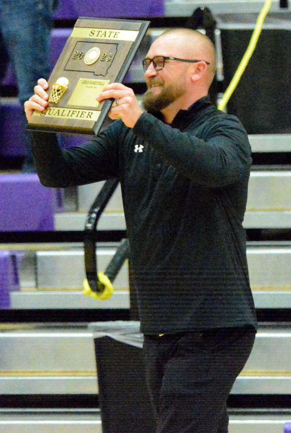 Watertown High School's head girls basketball coach Chad Rohde holds up the trophy after the Arrows' SoDak 16 Class AA state-qualifying victory over Sioux Falls Lincoln on Friday, March 3, 2023 in Watertown.