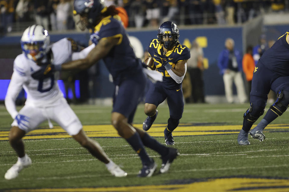 West Virginia's Jaheim White (22) carries the ball during the first half of an NCAA college football game against BYU on Saturday, Nov. 4, 2023, in Morgantown, W.Va. West Virginia won 37-7. (AP Photo/Chris Jackson)