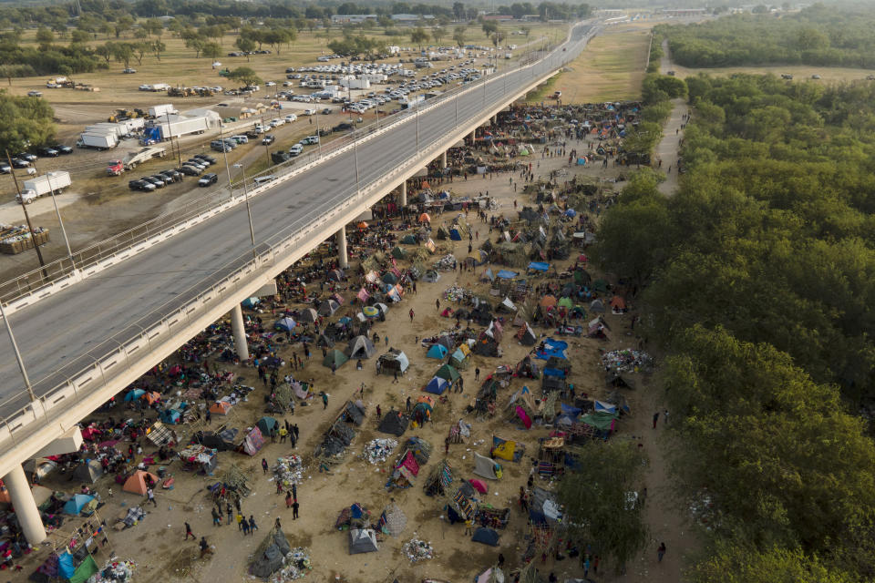 Migrants, many from Haiti, are seen at an encampment along the Del Rio International Bridge near the Rio Grande, Tuesday, Sept. 21, 2021, in Del Rio, Texas. The options remaining for thousands of Haitian migrants straddling the Mexico-Texas border are narrowing as the United States government ramps up to an expected six expulsion flights to Haiti and Mexico began busing some away from the border. (AP Photo/Julio Cortez)