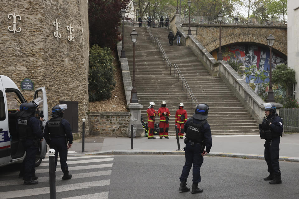 Police officers and rescue worker wait for instructions bar the the Iranian consulate, Friday, April 19, 2024 a in Paris. Paris police said Friday they are carrying out an operation at the Iranian consulate after a witness reported seeing a man outside carrying a grenade and an explosives vest. (AP Photo/Thomas Padilla)