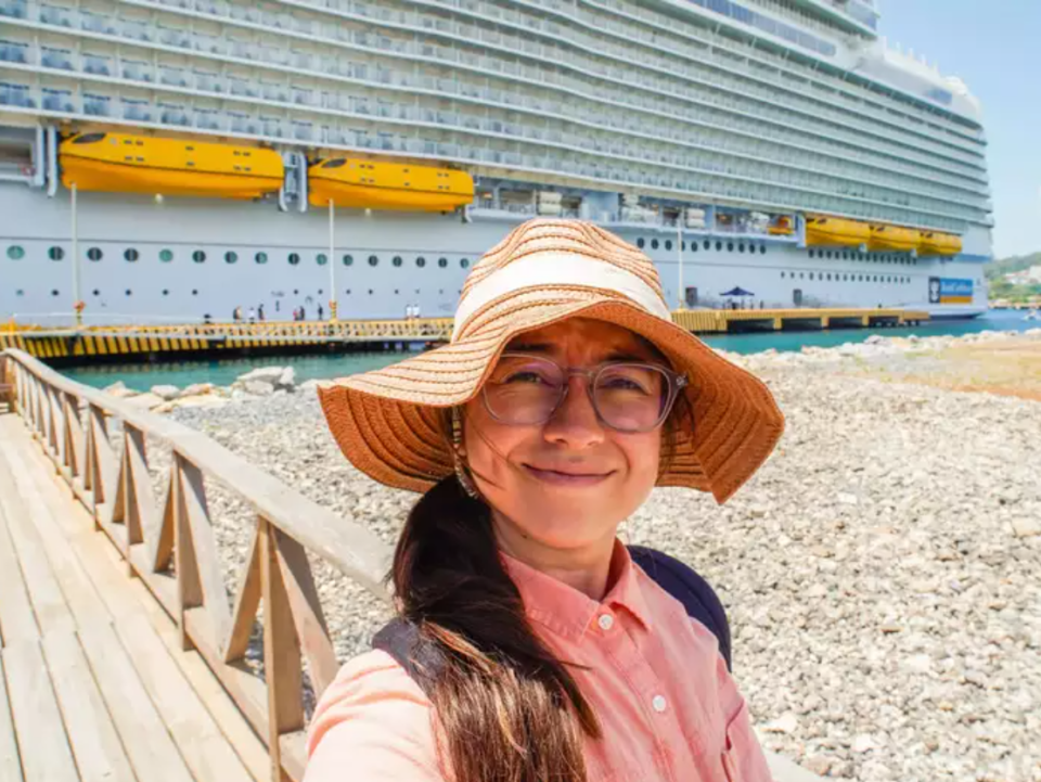 Unsere Autorin in einem Hafen vor dem größten Kreuzfahrtschiff der Welt. - Copyright: Joey Hadden/Insider