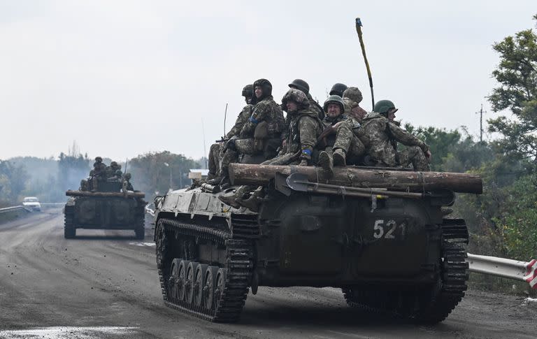 Soldados ucranianos sentados en vehículos de combate de infantería mientras conducen cerca de Izyum, en el este de Ucrania, el 16 de septiembre de 2022, en medio de la invasión rusa de Ucrania. (Foto de Juan BARRETO / AFP)