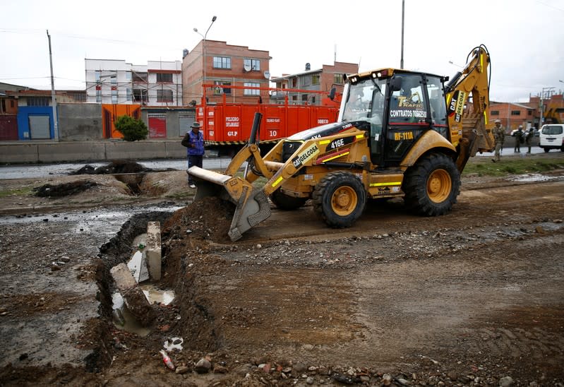 Una excavadora llena una zanja en el área bloqueada cerca de la planta de gasolina de Senkata para normalizar la distribución de combustible, en las afueras de El Alto de La Paz.