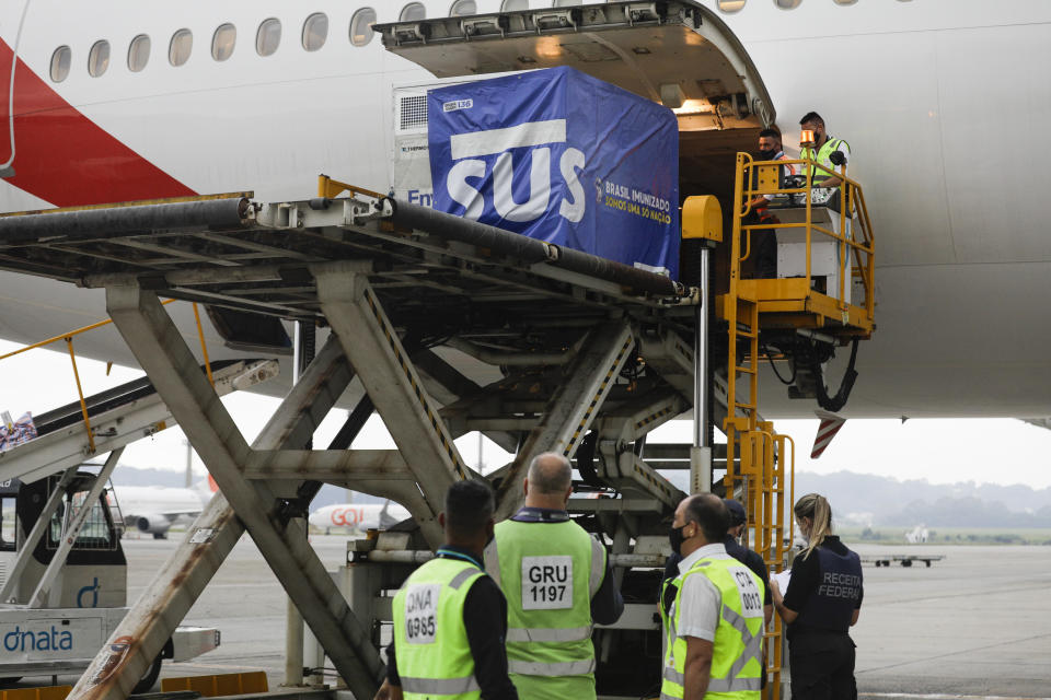 Un contenedor con vacunas contra el COVID-19 fabricadas por Oxford/AstraZeneca es bajado del avión a su llegada procedente de India en el aeropuerto internacional en Sao Paulo, Brasil, el viernes 22 de enero de 2021. (AP Foto/Marcelo Chello)