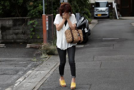 A fan of Kyoto Animation cries as she visits the area near the studios' building which was torched by arson attack, in Kyoto