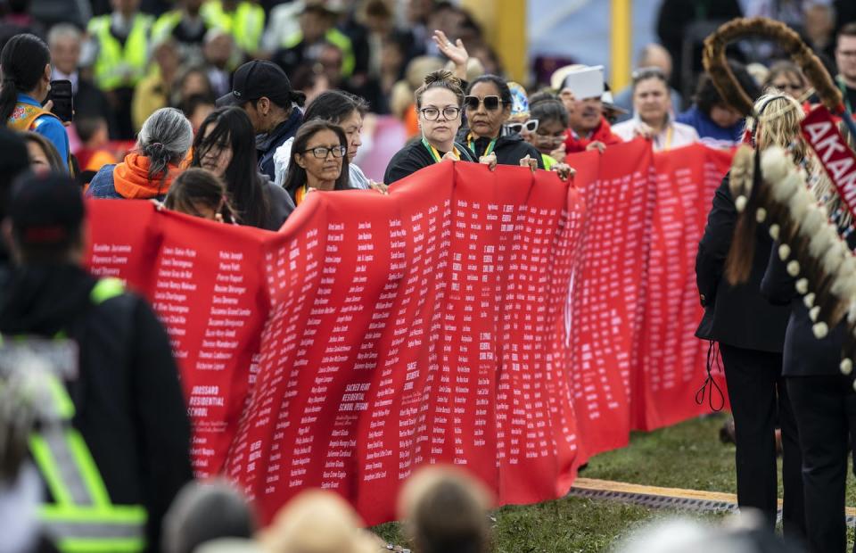 A group holds a banner with names of children on it, after Pope Francis’s address in Maskwacis, Alta., on July 25, 2022. THE CANADIAN PRESS/Jason Franson