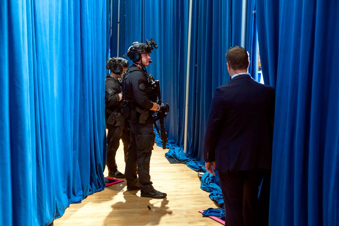 Security detail armed with long guns, stand backstage behind Vice President Kamala Harris as she delivers remarks during a campaign rally at Westover High School on Thursday, July 18, 2024 in Fayetteville, N.C.