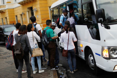 People board a bus minutes before the start time of a curfew enforced by Honduras government while the country is still mired in chaos over a contested presidential election in Tegucigalpa, Honduras, December 2, 2017. REUTERS/Edgard Garrido