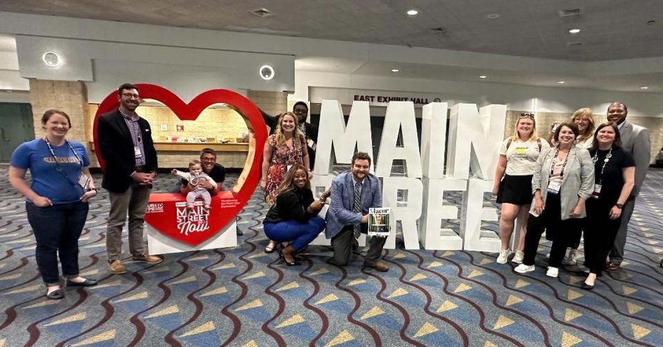 Representatives from NewTown Macon smile for a photo while attending a conference in Alabama. At the conference they were presented with the 2024 Great American Main Street Award.