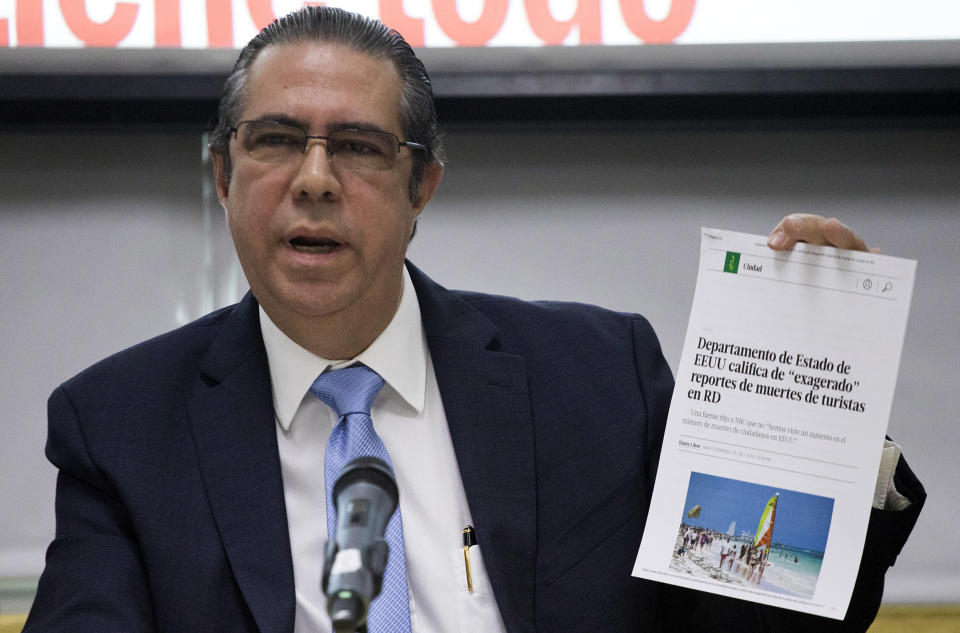 The Minister of Tourism of the Dominican Republic Francisco Javier García, holds a copy of an online article in a local paper saying the U.S. State Department considers recent reports on tourists' deaths to be exaggerated, at the Ministry of Tourism office in Santo Domingo, Dominican Republic, Friday, June 21, 2019. According to García the deaths of eight American tourists in the Dominican Republic this year are not part of a mysterious cluster but rather a medically and statistically normal phenomenon that has been irresponsibly lumped together by the U.S. media. (AP Photo/Tatiana Fernandez)