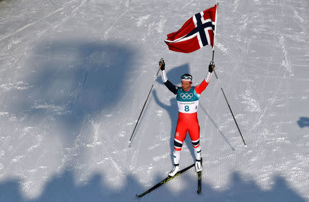 FILE PHOTO: Cross-Country Skiing - Pyeongchang 2018 Winter Olympics - Women's 30km Mass Start Classic - Alpensia Cross-Country Skiing Centre - Pyeongchang, South Korea - February 25, 2018 - Marit Bjoergen of Norway celebrates winning the race holding a Norway flag. REUTERS/Toby Melville/File Photo