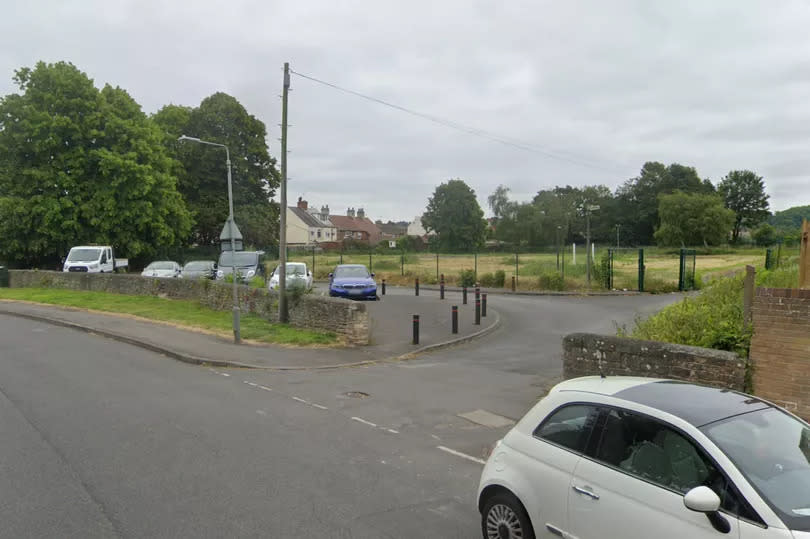 The site in Worksop due to house a new Nottinghamshire County Council office, with a row of parked cars seen infront of an empty field