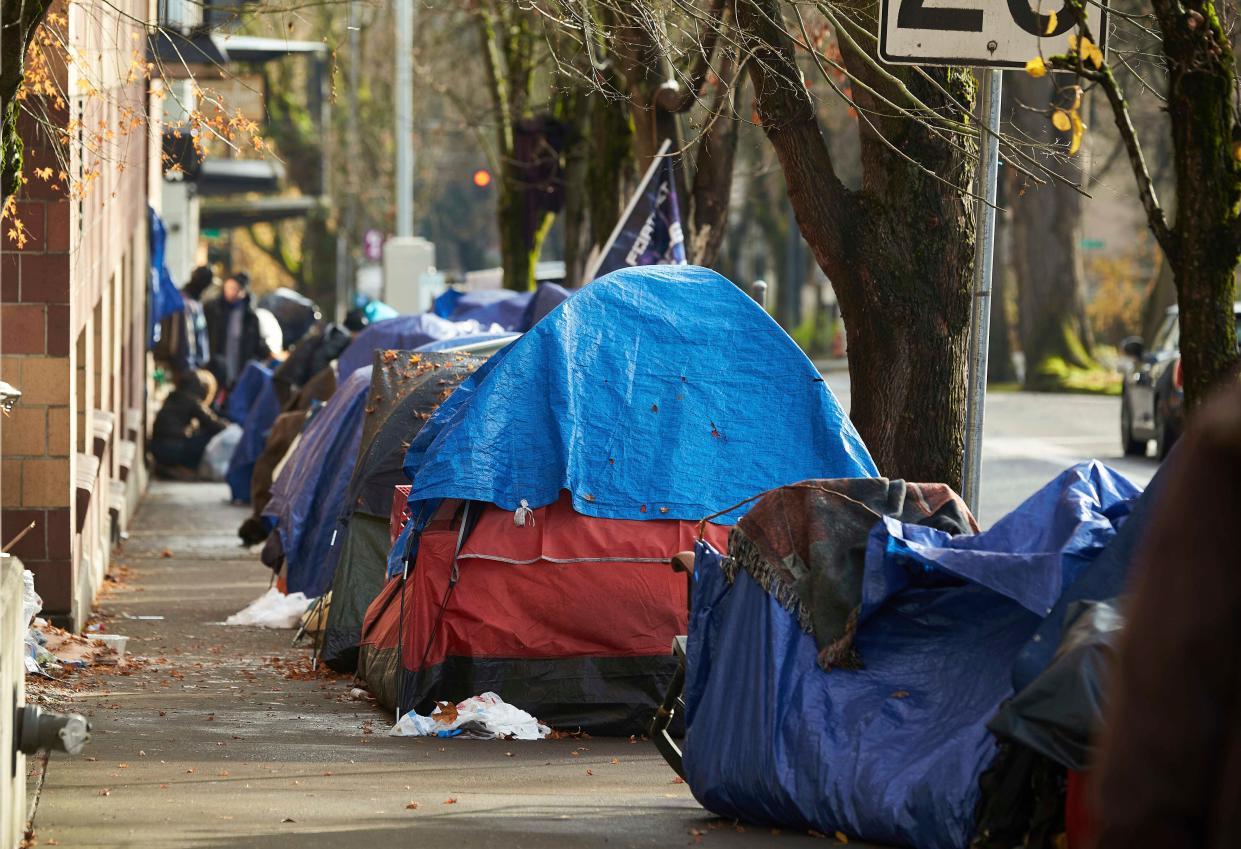 This file photo shows tents lining the sidewalk on SW Clay Street in Portland in 2020. According to an annual report released by regional officials Dec. 20, fentanyl and methamphetamine drove a record number of homeless deaths last year in Oregon's Multnomah County, home to Portland.