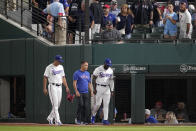 Texas Rangers right fielder Adolis Garcia, right, is escorted off the field by head athletic trainer Matt Lucero, center, and associate manager Will Venable, left, after an injury in the second inning of a baseball game against the Houston Astros, Wednesday, Sept. 6, 2023, in Arlington, Texas. (AP Photo/Tony Gutierrez)