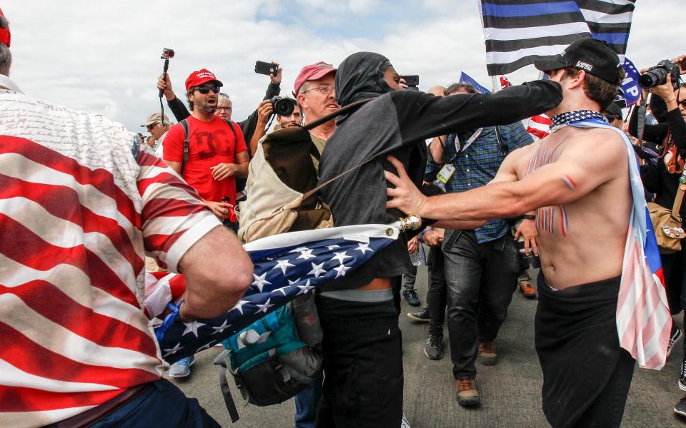 Supporters of President Donald Trump scuffle with counter-protesters during a rally in Huntington Beach, California, on Saturday - Credit: Irfan Khan/Los Angeles Times via AP