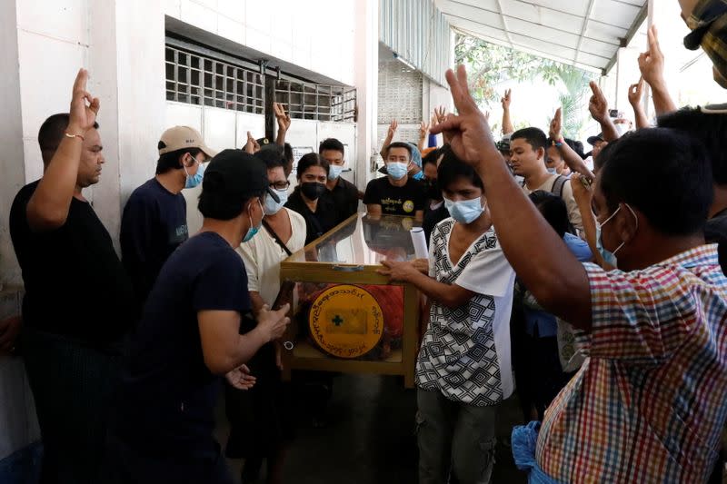 Waiting relatives react outside the morgue as the body of one anti-coup protester is released at Thingangyun Hospital in Yangon