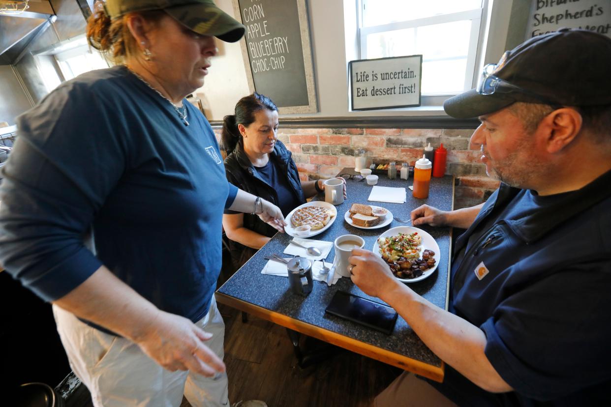 Kathy DeTerra brings out a breakfast order at the Little Phoenix Restaurant on Acushnet Avenue in New Bedford.