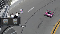 Helio Castroneves drives the Acura DPi takes the checker flag to win the Rolex 24 hour auto race at Daytona International Speedway, Sunday, Jan. 30, 2022, in Daytona Beach, Fla. (AP Photo/David Graham)