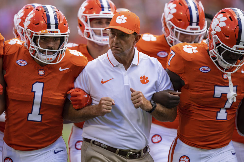 Clemson head coach Dabo Swinney walks arm in arm with his players before an NCAA college football game against Charleston Southern on Saturday, Sep. 9, 2023, in Clemson, S.C. (AP Photo/Jacob Kupferman)