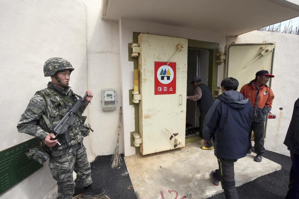 In this photo provided by the Ongjin County, a South Korean soldier stands as residents of Socheong Island evacuate to a shelter on the island, South Korea, near the West Sea border with North Korea, Tuesday, April 29, 2014. North Korea conducted live-fire artillery drills Tuesday near the countries' disputed western sea boundary, South Korean military officials said, in a possible indication of rising frustration in Pyongyang as it unsuccessfully pushes for outside aid. (AP Photo/Ongjin County)