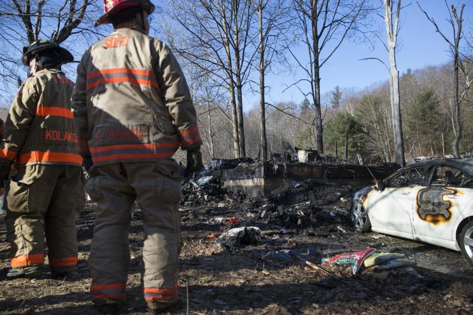 South Deerfield firemen stand at the scene following a deadly house fire, Saturday, March 4, 2017, in Warwick, Mass. A mother and four children were killed when flames swept through their rural Massachusetts home early Saturday, fire officials said. Two other family members escaped the fire, which broke in the single-family house. (Kieran Kesner /The Boston Globe via AP, Pool)