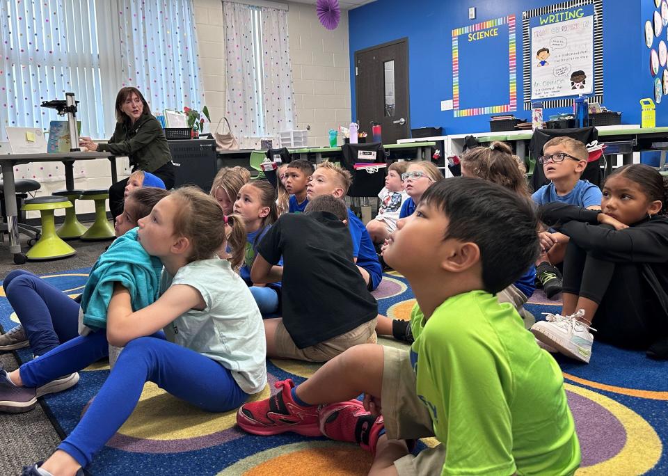 Volunteer Mary Glass of the Manatee Education Foundation joins kindergarteners at Harvey Elementary in Parrish for EOD's “Bucket Fillers” initiative.
