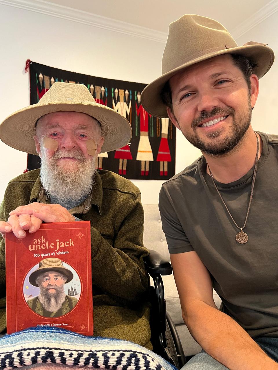 Unlce Jack holding his book, "Ask Uncle Jack: 100 Years of Wisdom," and his grand-nephew, Damon