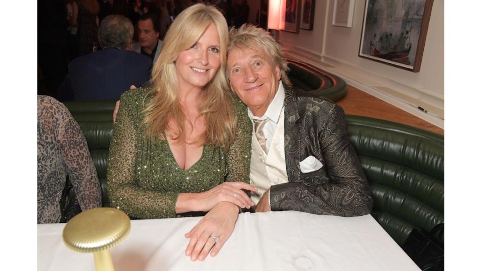 Penny Lancaster and Sir Rod Stewart sitting at table smiling