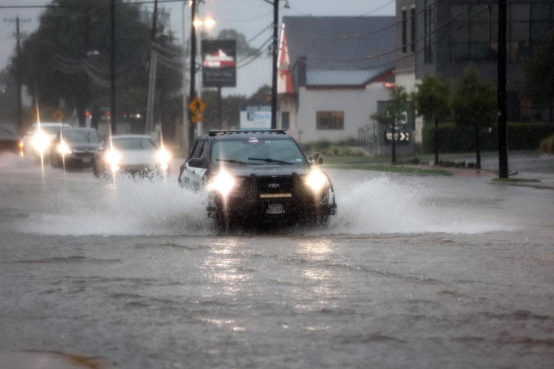 A Fort Worth Police Department vehicle drives through a flooded section of University Drive on Monday, August 22, 2022.