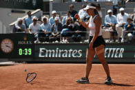 Jessica Pegula of the U.S.walks to pick up her racket as she plays Poland's Iga Swiatek during their quarterfinal match of the French Open tennis tournament at the Roland Garros stadium Wednesday, June 1, 2022 in Paris. (AP Photo/Thibault Camus)
