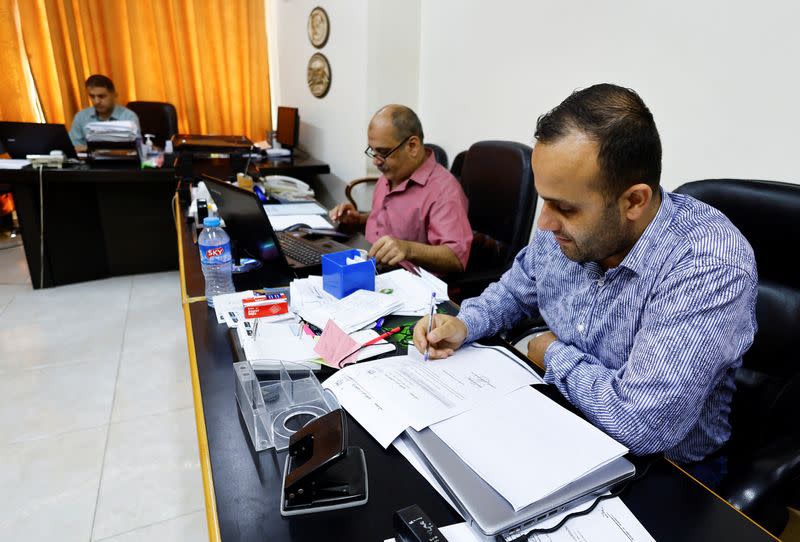 Palestinians employees work at Gaza government media office, in Gaza City