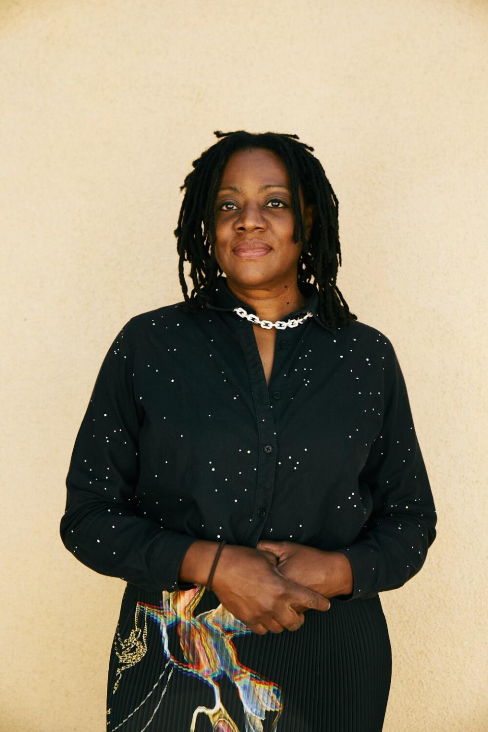 Cauleen Smith smiles in a black dress.